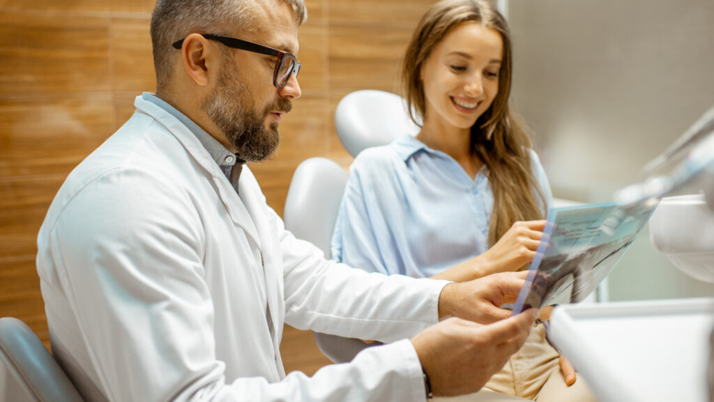 St. Louis cosmetic dentist explaining a treatment plan and dental X-rays to a patient.