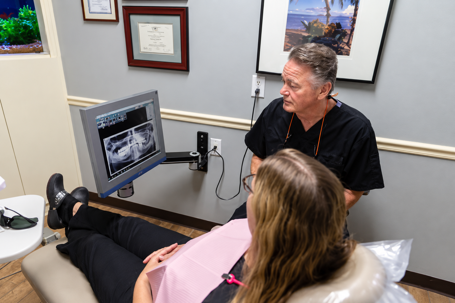 St. Louis County Dental dentist showing a patient their X-ray on a monitor during a chairside consultation about dental implants for missing teeth